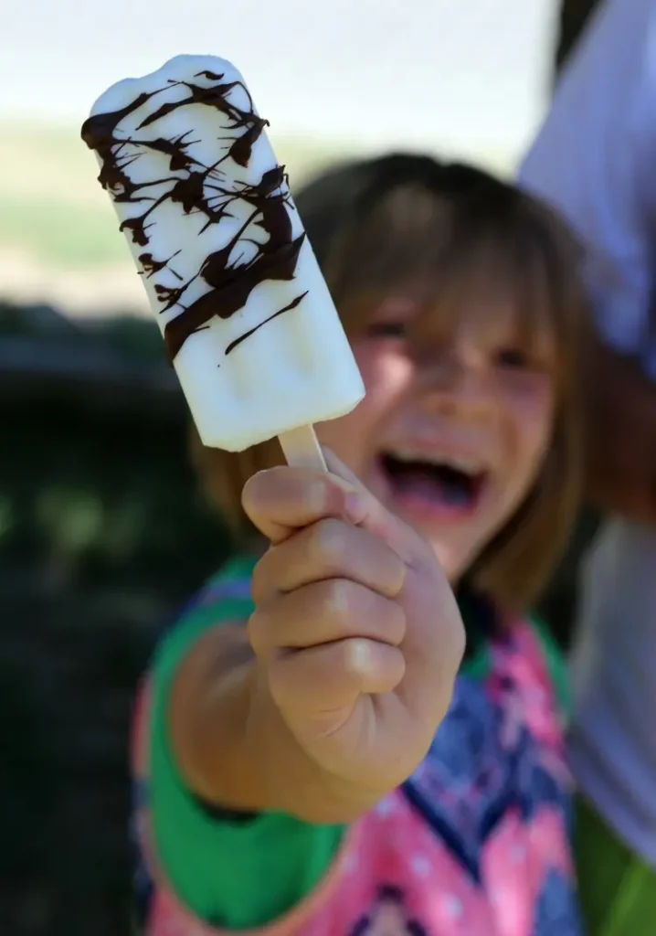 Creamy Coconut Fruit Bars with Chocolate Drizzle 12 jenn brockman daughter madisyn worden holding coconut oushine bar with chocolate drizzle