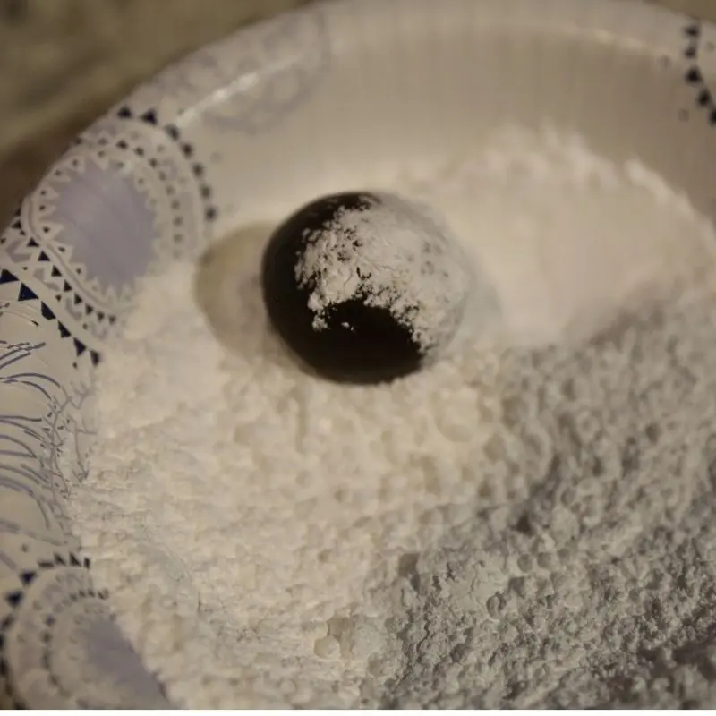 5-Ingredient Fudgy Brownie Crinkle Cookies 13 rolling brownie cookie dough in powder sugar | Half Baked Media