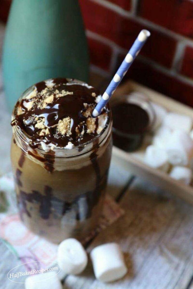 s'more's Coffee with blue straw chocolate syrup, whipping topping and graham crackers on top