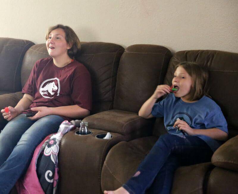 jenn brockman girls sitting on couch wating movie