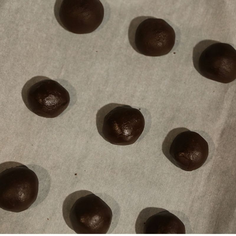 brownie cookie dough rolled into balls on cookie sheet | Half Baked Media