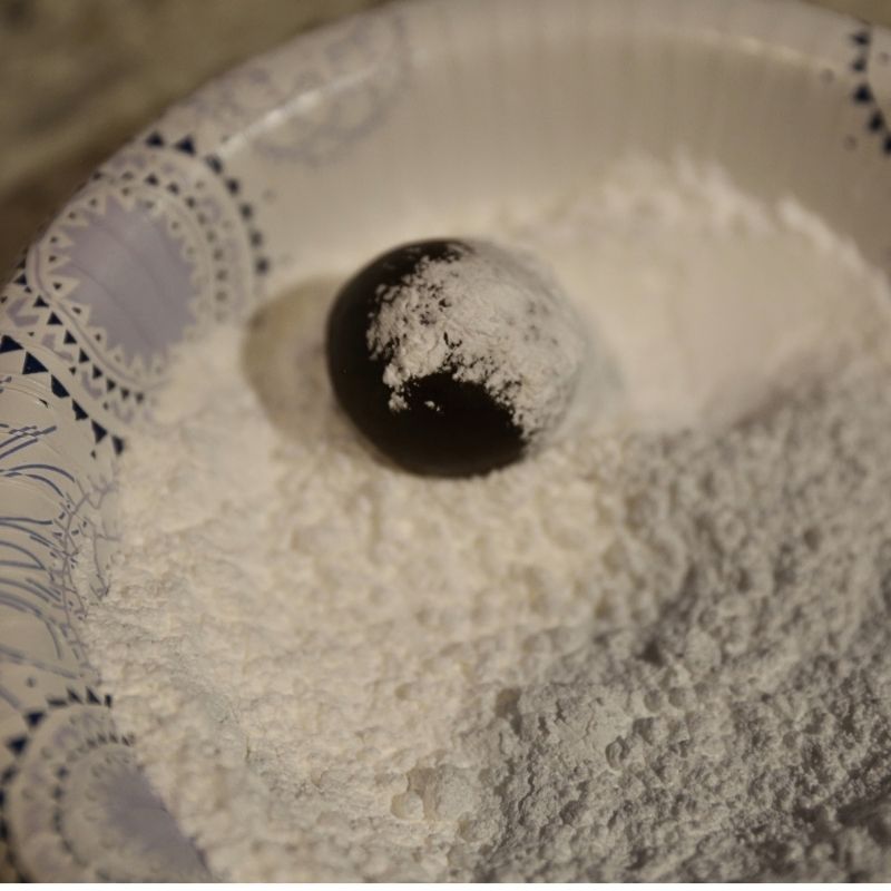 rolling brownie cookie dough in powder sugar | Half Baked Media